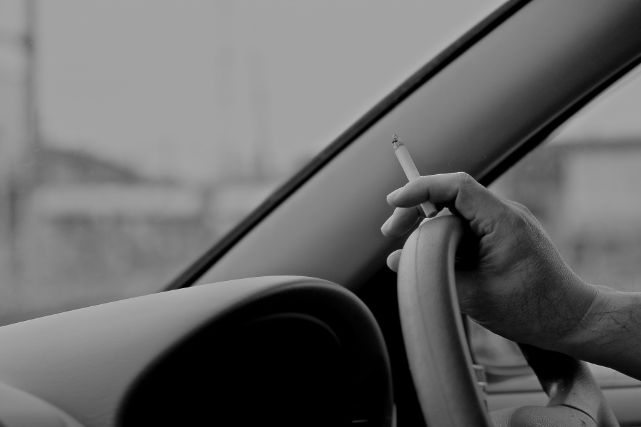 タバコを持ちながら運転する人